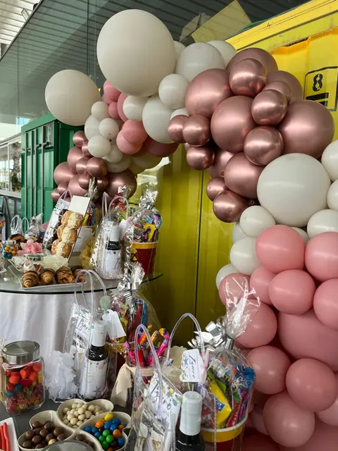 Decoración de globos junto a un contenedor