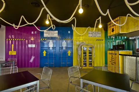 Interior con contenedores de colores y guirnaldas de luces