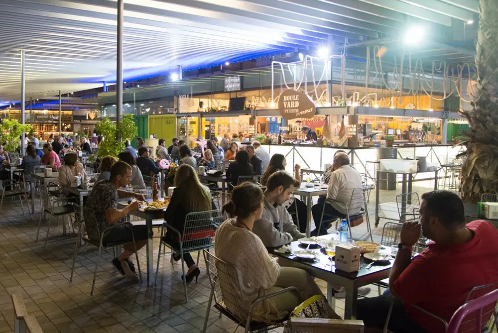 Terraza cubierta llena de gente por la noche